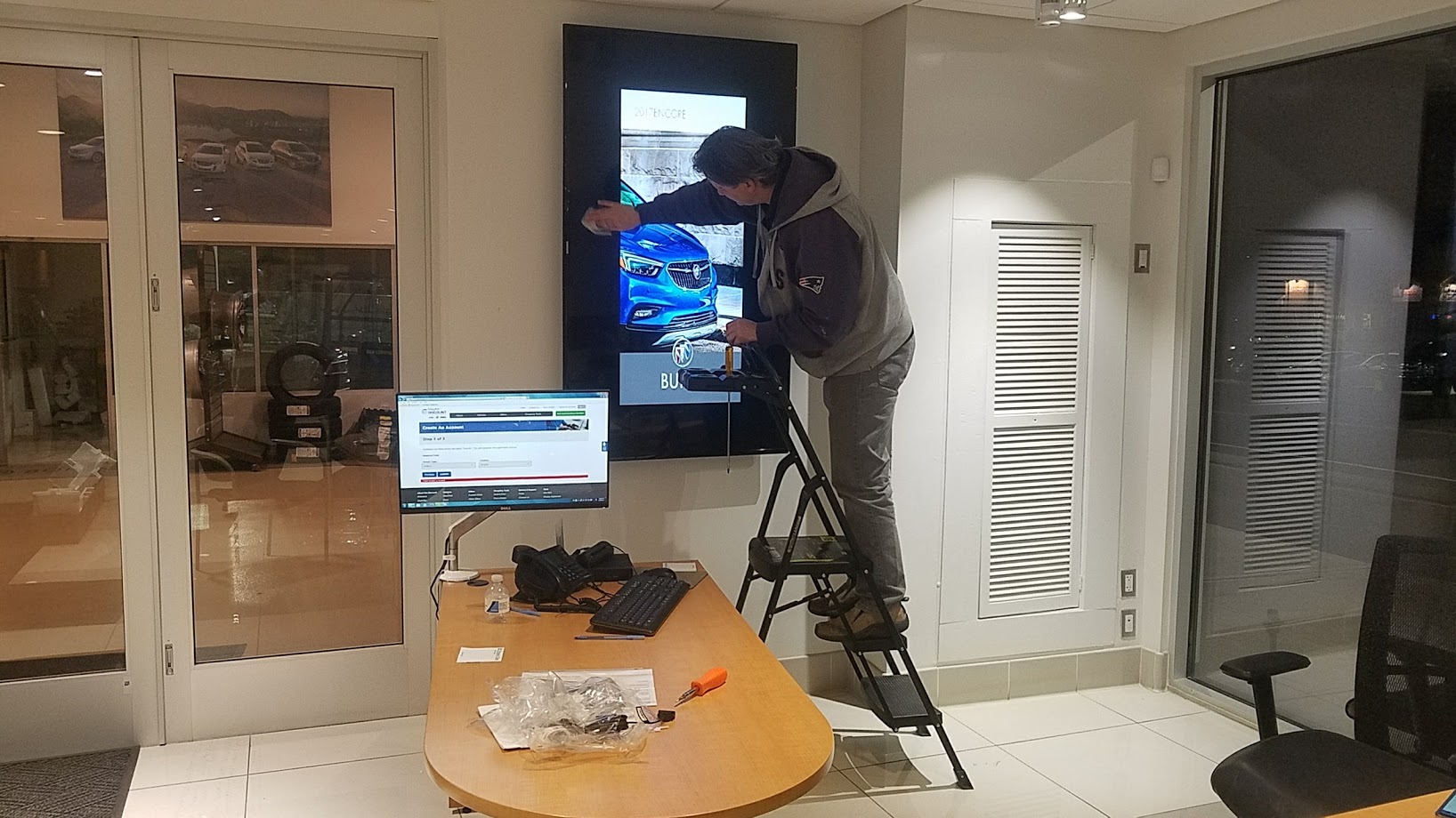 Technician configuring a wall-mounted commercial display