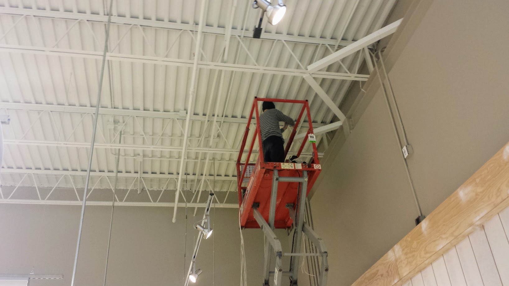 Technician installing overhead cabling in a commercial space