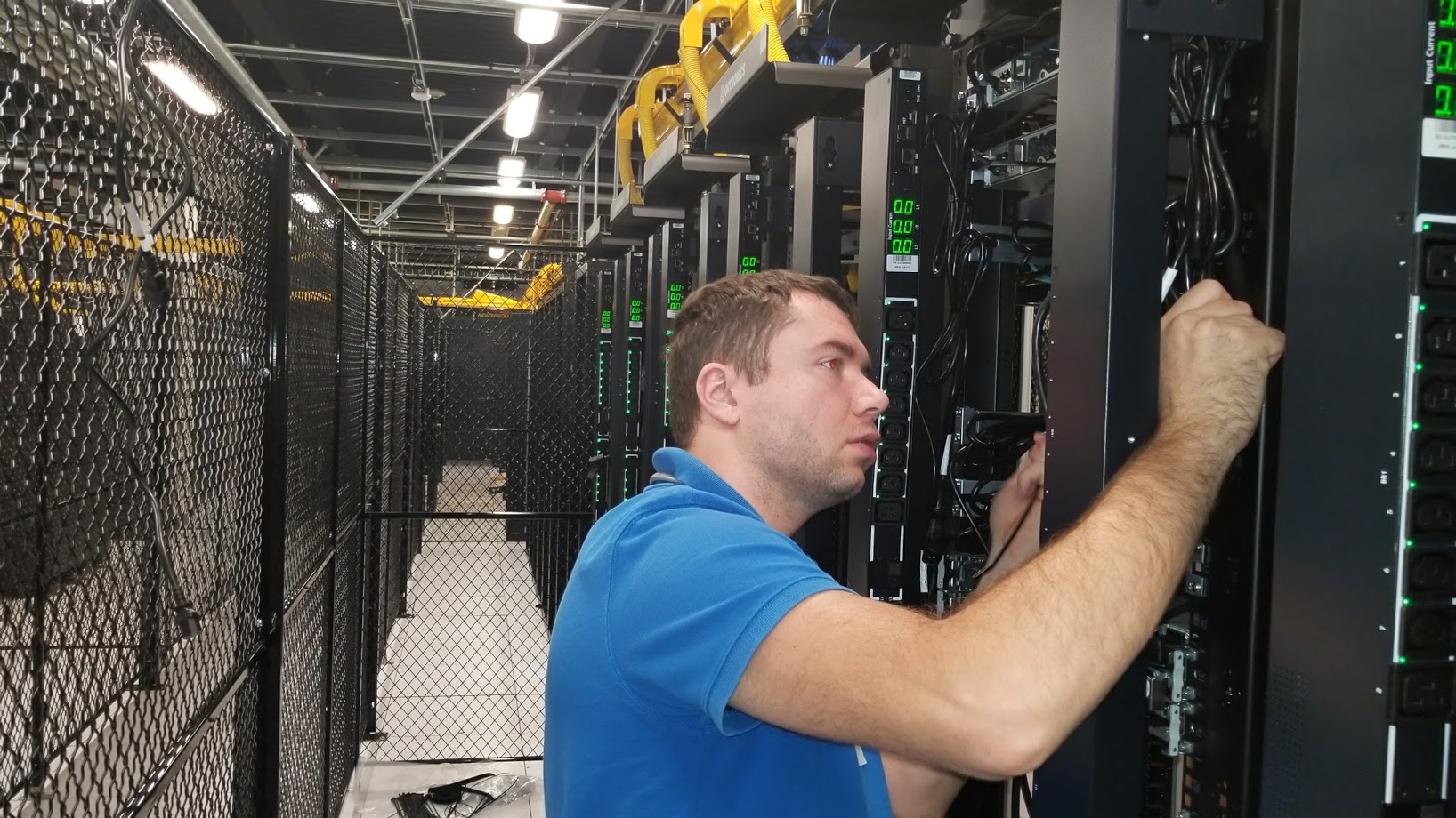 Technician working inside a commercial data center rack